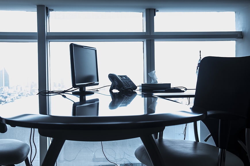Silhouette of modern office desk with computer and city view