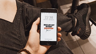 Person holding smartphone with motivational quote on screen