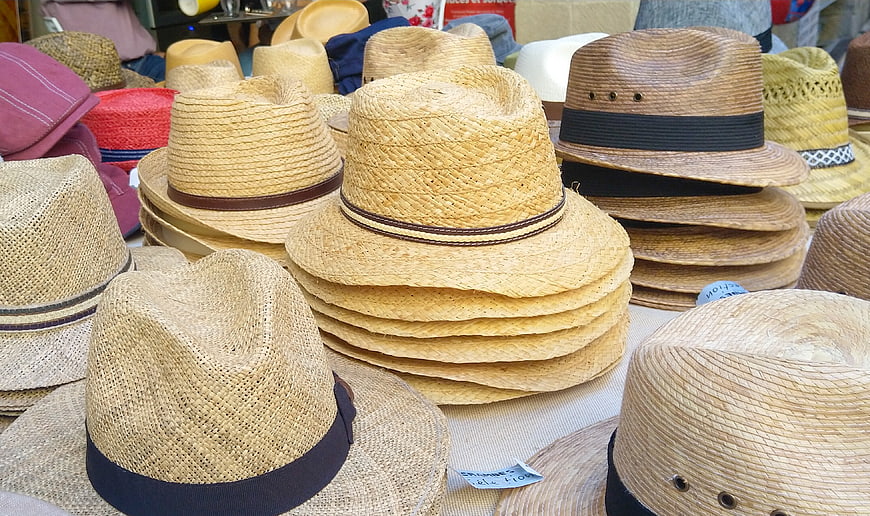 Stacks of woven straw hats for sale at a market