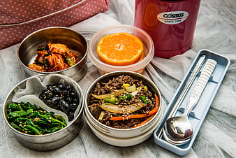 Korean bento box lunch with beef, kimchi, and orange