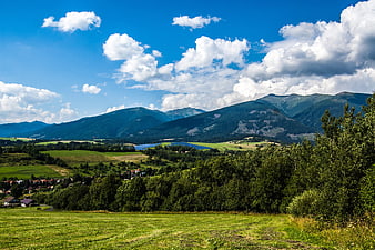 Scenic mountain landscape with green meadows and blue sky