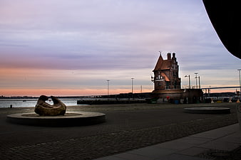 Sunset at Warnemünde with historic tower and sculpture