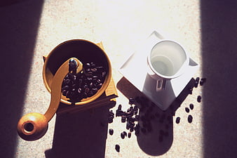 Top view of coffee grinder and cup in sunlight