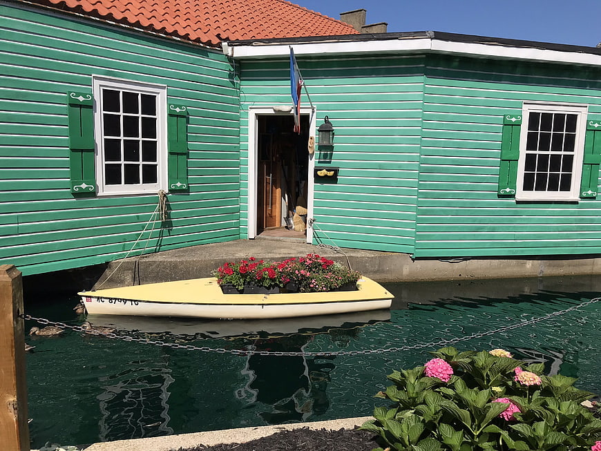 Green floating house with flower boat in canal