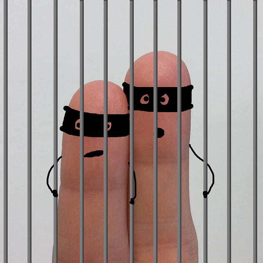 Finger puppets dressed as thieves behind jail bars
