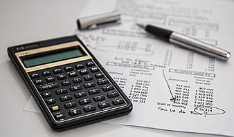 Calculator and pen on financial investment documents