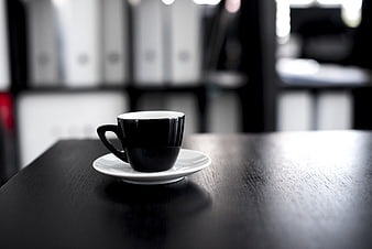 Black Coffee Cup on Dark Wooden Desk in Office