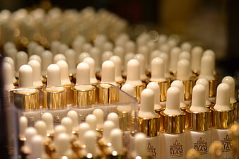 Rows of Royal Siam Skincare Dropper Bottles with Gold Caps