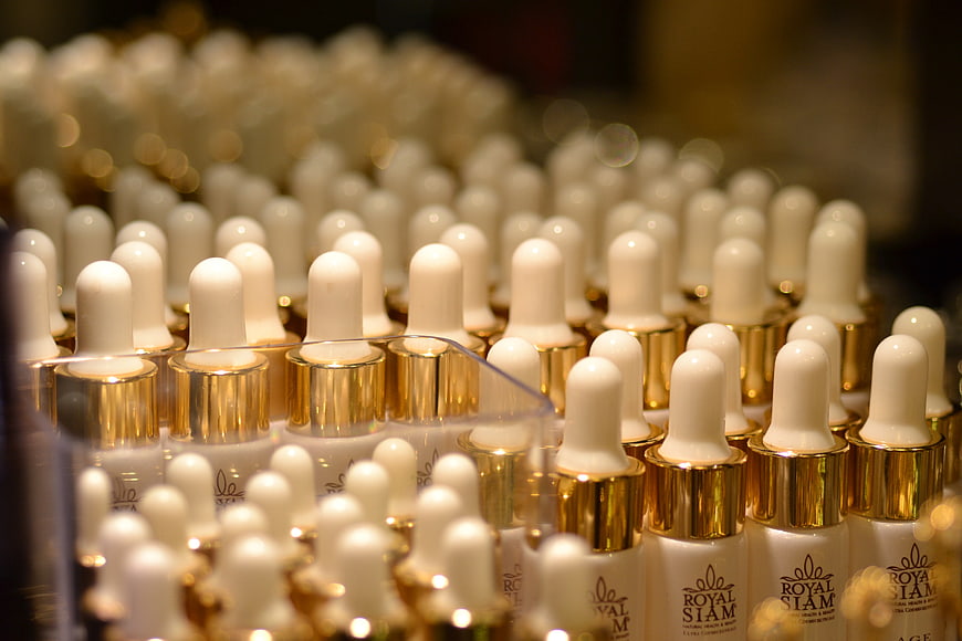 Rows of Royal Siam Skincare Dropper Bottles with Gold Caps