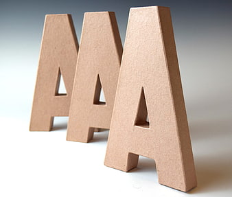 Three wooden letter A blocks spelling AAA on white background
