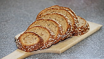 Sliced Whole Grain Rye Bread with Sesame Seeds on Wooden Board