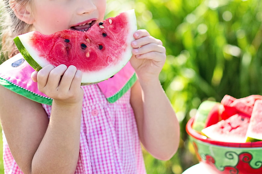 Little Girl Eating Watermelon Slice Outdoors
