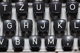 Close-up of vintage typewriter keys with white letters on black background