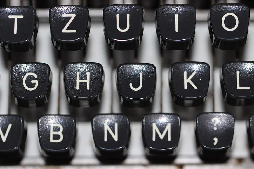 Close-up of vintage typewriter keys with white letters on black background