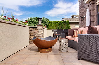 Modern Outdoor Patio With Rustic Fire Pit And Wicker Seating