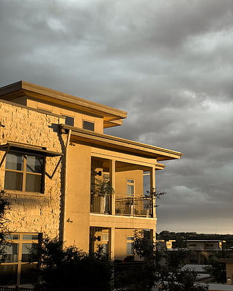 Modern Apartment Building with Balconies Under Dramatic Cloudy Sky