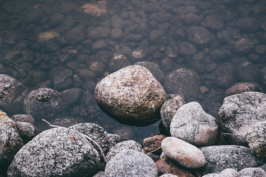 Clear shallow water with smooth river stones and rocks