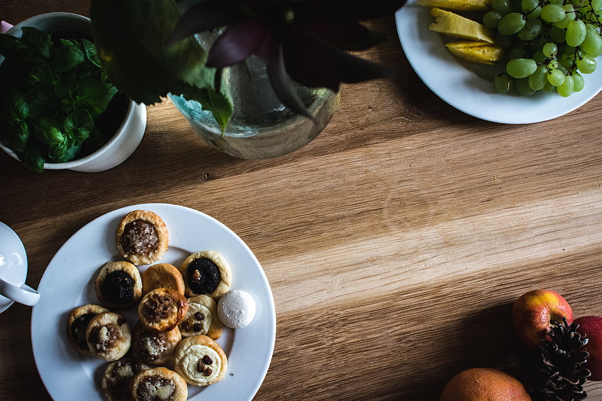 Top view of assorted pastries and fruit on a wooden table