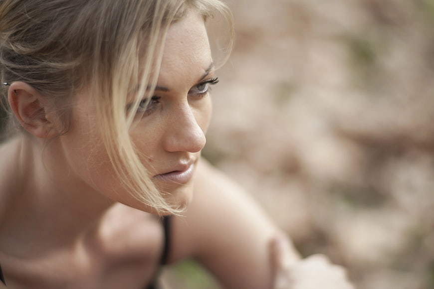 Close-up portrait of contemplative blonde woman outdoors