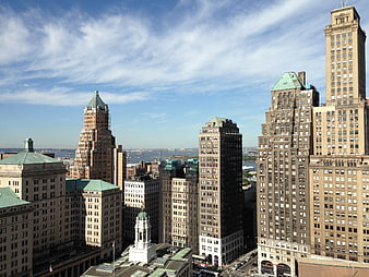 Cityscape of historic brownstone skyscrapers under blue sky