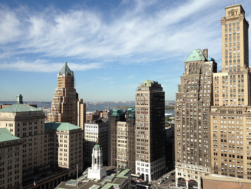 Cityscape of historic brownstone skyscrapers under blue sky