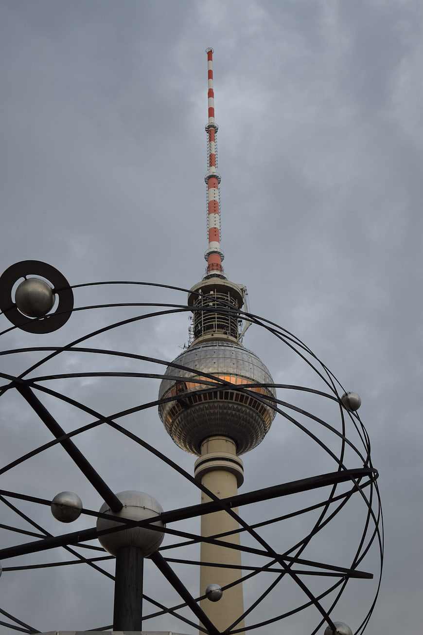 Berlin TV Tower Framed by Metal Sculpture Against Cloudy Sky