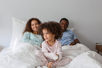 Happy African American Family in Bed with Daughter
