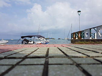 Low angle view of harbor boats from tiled pier