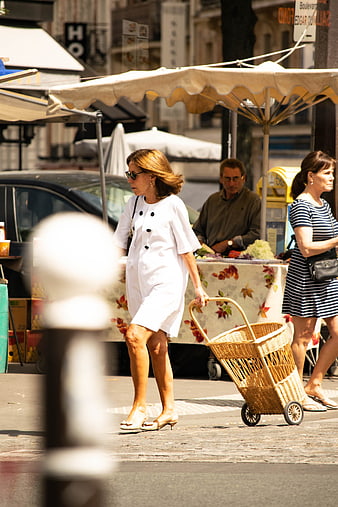 Stylish Woman Walking with Wicker Shopping Basket on City Street