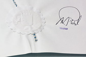 Close-up of Notarized Document with White Wax Seal and Signature