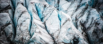 Close-up of textured glacier ice with deep blue crevasses
