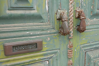 Vintage Green Wooden Door with Peeling Paint and Hand Knocker