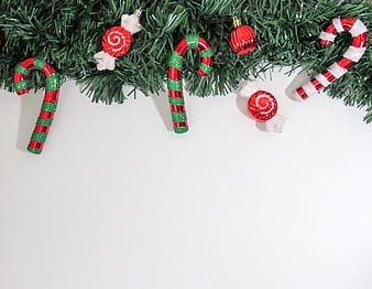 Christmas garland with candy cane ornaments on white background