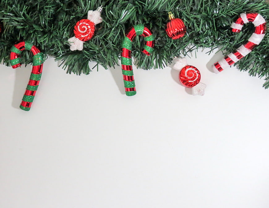 Christmas garland with candy cane ornaments on white background