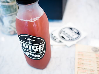 Pink Juice Bottle with Black Label on White Marble
