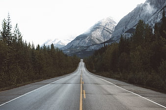 Empty Mountain Road Leading to Snowy Peaks