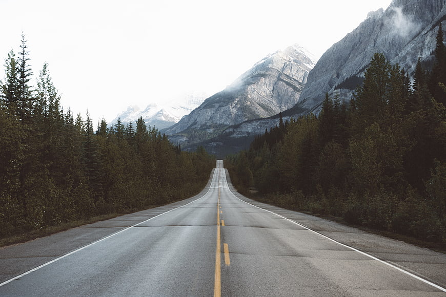 Empty Mountain Road Leading to Snowy Peaks