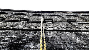 Yellow Ropes on Textured Stone Dam Wall