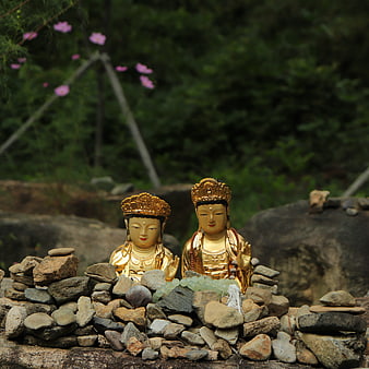 Golden Buddha Statues on Stone Cairn in Garden