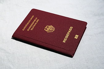German Passport Lying On White Textured Fabric Surface
