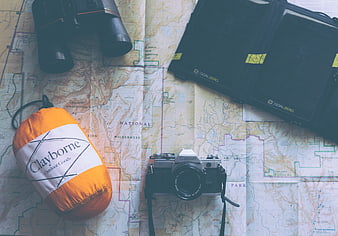 Vintage camera, map, and outdoor gear flat lay