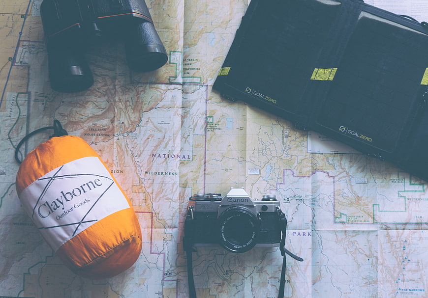 Vintage camera, map, and outdoor gear flat lay