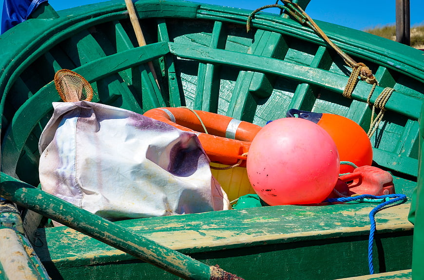 Close-up of green fishing boat interior with orange buoys and gear
