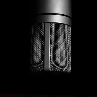 Close-up of silver studio microphone on black background