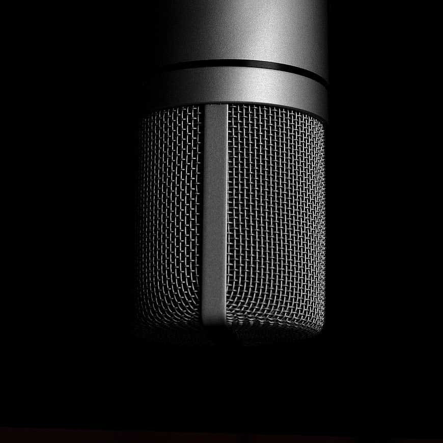 Close-up of silver studio microphone on black background