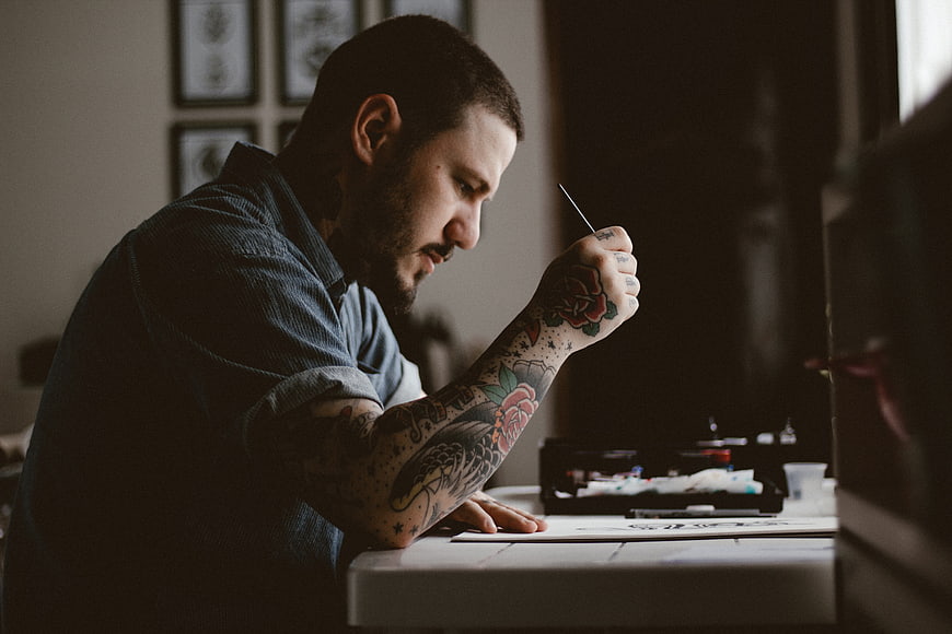 Tattoo artist drawing design with pen