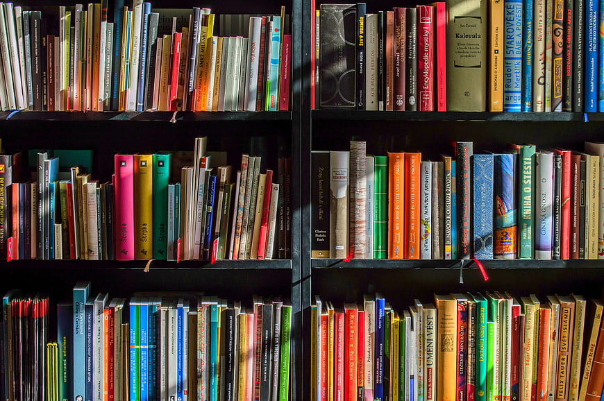 Colorful Books on Dark Wooden Shelves in Library