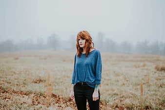 Redhead woman standing in foggy field