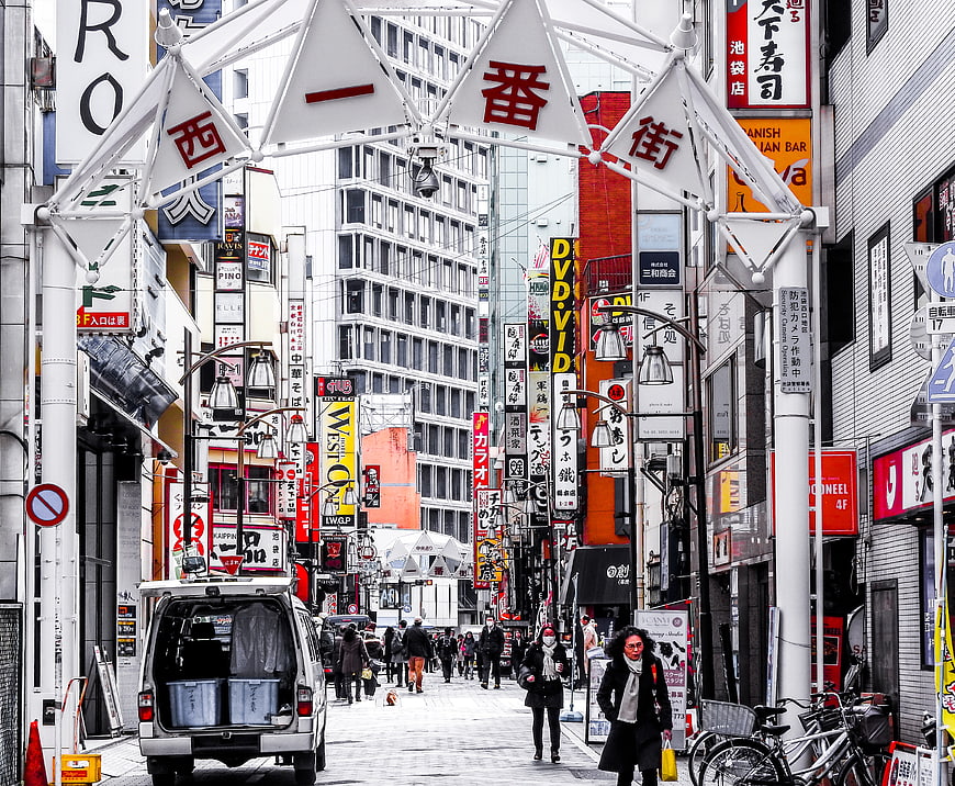 Busy Nishi-Ichibangai Street in Osaka with Pedestrians and Signs