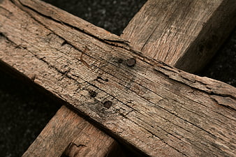 Close-up of weathered wooden cross with rusty nails